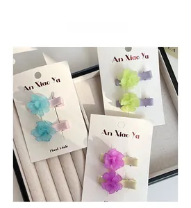 Detail of sweet floral hair clips for girls in blue green and purple pastel colors