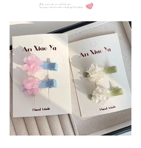 Detail of handmade flower hair clips with pastel petals and satin covered alligator clips
