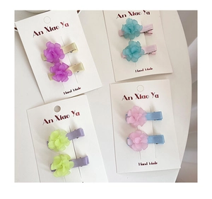 Detailed macro view of four sets of colorful matte resin flower hair clips for girls