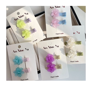 Detail of colorful floral duckbill hair clips with matte texture on display card