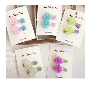 Detail view of colorful dual-layer floral hair clips with satin wrapped duckbill pins