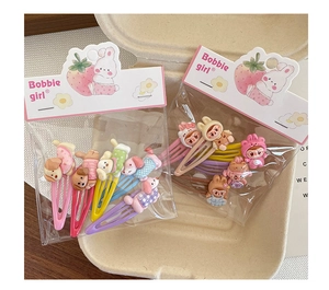 Detailansicht bunter Cartoon-Haarspangen in einer rosa dekorativen Geschenkverpackung