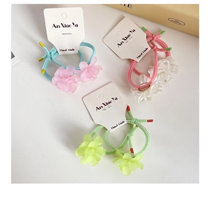 Detailed macro view of three elastic flower hair ties with colorful braided ropes and petals