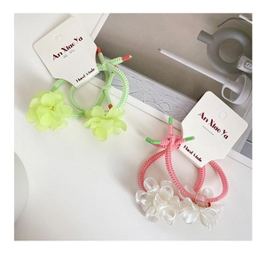 Close-up of handmade floral hair ties with matte flower charms and pearl accents