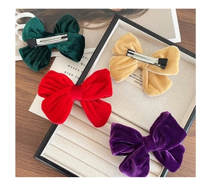 Detail view of velvet bow hair clips in four colors with black metal alligator clips