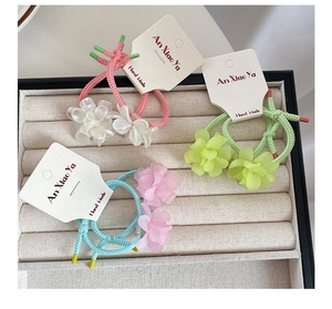 Detailed macro view of colorful woven flower hair ties on a white display card