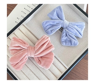 Detail of pink and blue velvet bow hair clips with soft fabric texture on display