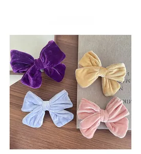Flat lay of colorful velvet bow hair clips in purple, yellow, blue and pink colors