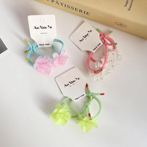 Three colorful floral hair ties with matte flower charms on a card display