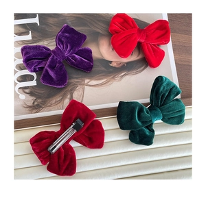 Detail view of colorful velvet bow hair clips with silver metal duckbill clip backings