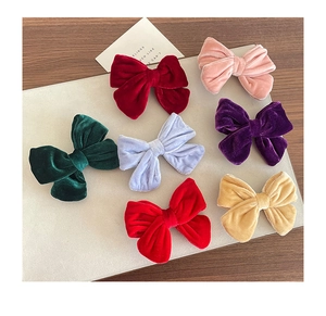 Flat lay of colorful velvet bow hair clips in a premium seven-piece styling set