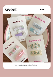 Détail de barrettes à fleurs en dentelle faites main avec broderies et perles