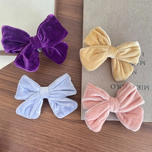 Set of four colorful velvet bow hair clips in purple, blue, beige, and pink for girls