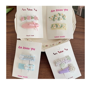Vue détaillée des barrettes artisanales avec dentelle, broderie et perles pour filles
