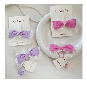 Detailed set of sweet candy-colored lace bow hair clips and elastic hair ties on display