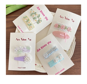 Détails de pinces à cheveux artisanales en dentelle et fleurs sur carte de support