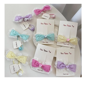 Detail of sweet macaron lace bows with heart charms and handmade fabric texture