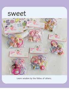 Detail view of 6-piece kids hair tie sets featuring cute cartoon resin charms and candy colors