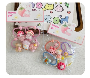 Detail view of cartoon hair ties with resin strawberry and bunny charms in packs