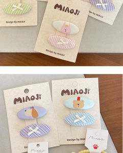 Detailed view of pastel fabric hair clips with cute cartoon bears and plaid patterns