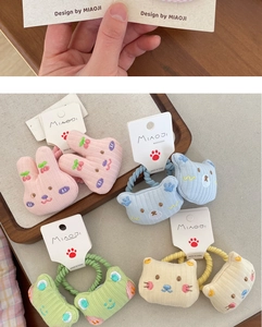 Detailed close-up of cute 3D embroidered cartoon bear and animal fabric hair ties for kids