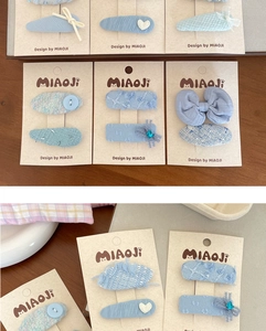 Detailed macro shot of blue tweed bow hairpins with lace and rhinestones on card
