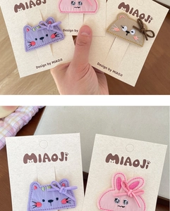 Detailed macro view of handmade embroidered animal hair clips with cute bow decorations