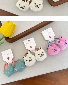 Detailed view of hand-embroidered animal hair ties with cute cats and rabbits in soft colors