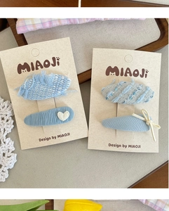 Detail of blue tweed hair clips and denim clips with heart embroidery on display cards