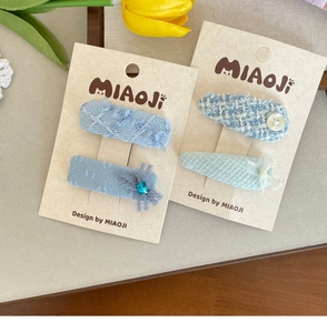 Detailed set of blue tweed hair clips with lace and heart rhinestones on display