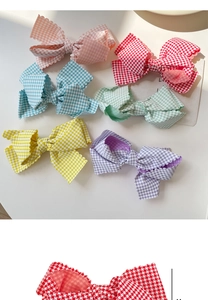 Detailed top view of plaid bow hair clips in six pastel colors with wavy edges