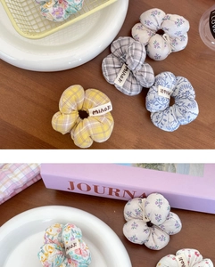 Détail de chouchous en tissu à fleurs et à carreaux sur une table en bois naturel