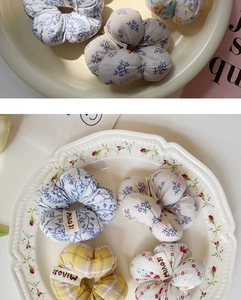 Détail de chouchous en tissu aux motifs floraux variés avec étiquettes de marque sur plat