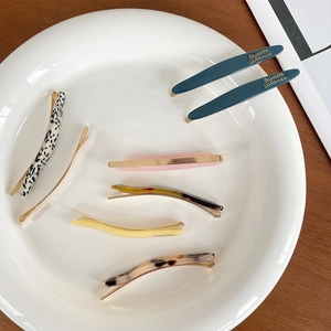 Elegant French acetate hair clip set in various colors displayed on a ceramic plate