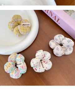 Détail de chouchous en tissu floral aux motifs variés avec étiquettes de marque cousues