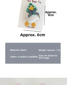 Detailed view of a handmade white plush duck hair clip with a green plaid headscarf