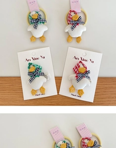 Detail of handmade cute duck hair clips and elastic ties with soft plush texture