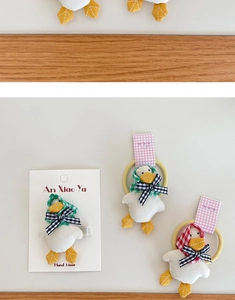 Close-up of handmade duck plush hair clips and ties with cute checkered scarves