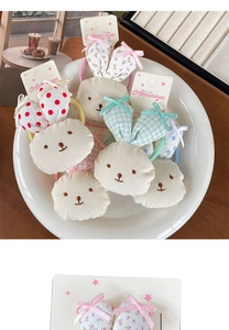 Detail of plush bunny hair ties with colorful patterns and embroidery on a white plate