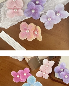 Detail of silk orchid flower clips with pearls for hair, perfect for seaside vacations