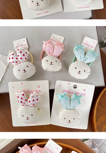 Detail of handmade rabbit hair clips for girls with red polka dots and plaid fabric texture