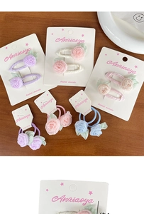 Détail de pinces à cheveux et élastiques en tissu faits main sur des cartes blanches