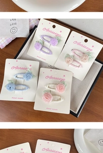 Détail de quatre pinces à cheveux camélia en tissu fait main en violet rose bleu beige