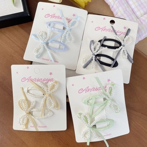 Set di quattro fermagli per capelli con fiocco di perle e nastro a quadretti su legno
