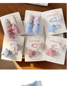 Détail de barrettes à fleurs et nœuds faits main pour filles sur un plateau en bois