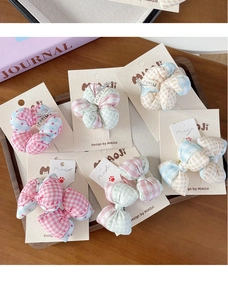 Détail de chouchous en tissu à carreaux et barrettes nœuds avec motifs cœurs