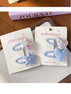 Détail de barrettes à cheveux faites main en tissu floral bleu étoilé et cœur