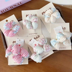 Ensemble de chouchous et barrettes en tissu à carreaux sur un plateau en bois