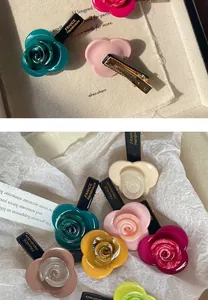 Detail of elegant handmade rose acetate hair clips with golden French lettering