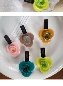 Detailed view of colorful rose acetate hair clips with gold handmade lettering